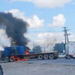 Tractocamión en llamas y columna de humo negro sobre una vialidad durante los bloqueos en Matamoros, Tamaulipas