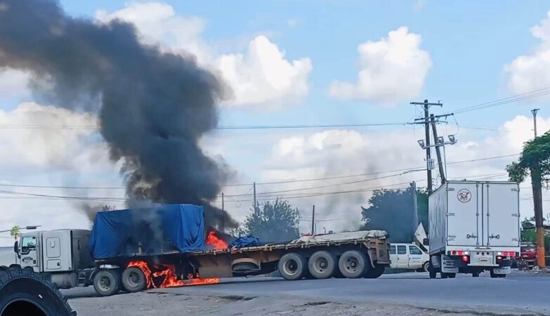 Tractocamión en llamas y columna de humo negro sobre una vialidad durante los bloqueos en Matamoros, Tamaulipas